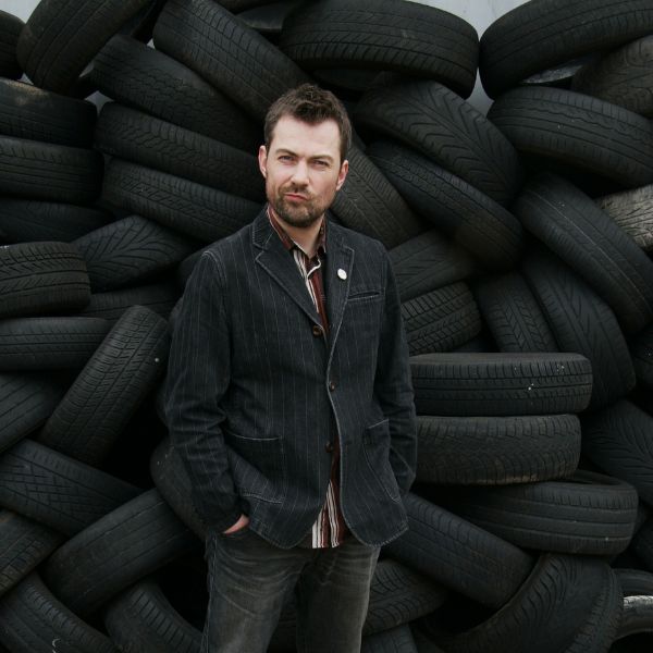 Ben standing in front of a wall of tyres