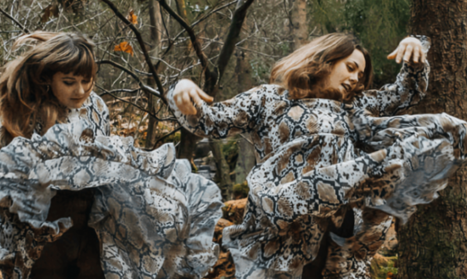 Group of two in woodland with dresses blown around showing movement