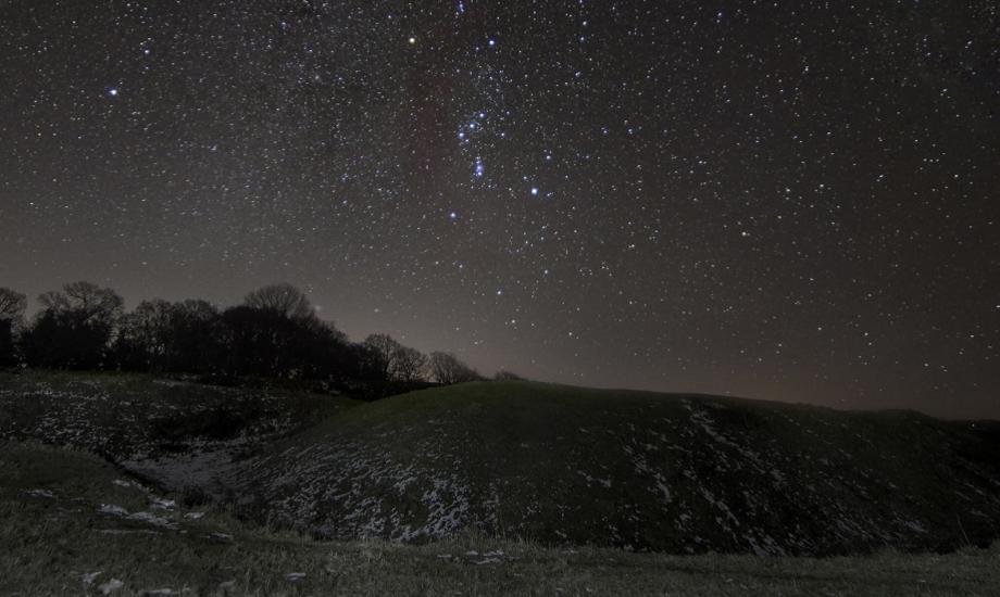 Sky over a burial mound on Cranborne Chase. The night sky is clear and  dark and full of stars