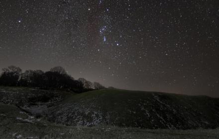Sky over a burial mound on Cranborne Chase. The night sky is clear and  dark and full of stars